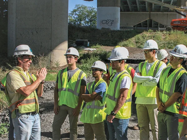 students and professor out in the field learning about bridge repairs and structure