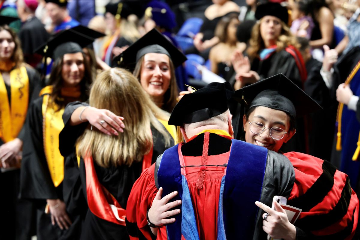 Students hugging through procession line