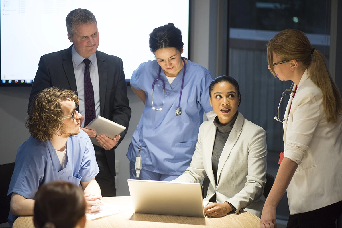 Healthcare Administration individuals discussing at a table.