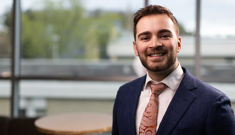 student in a suit smiling