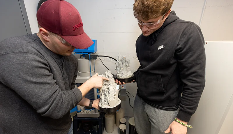 civil engineering degree students operating a machine at the civil engineering school