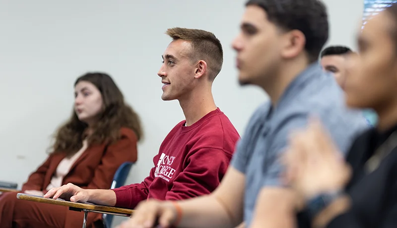 3 students sitting at desks in class