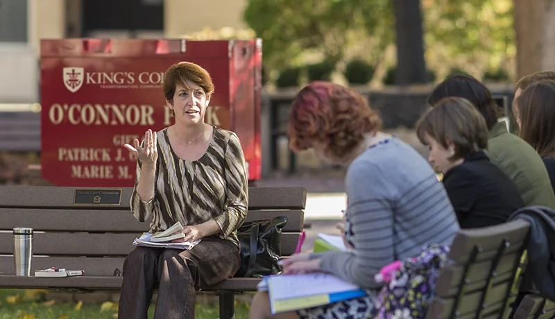 literature degree professor teaching english literature degree students outdoors