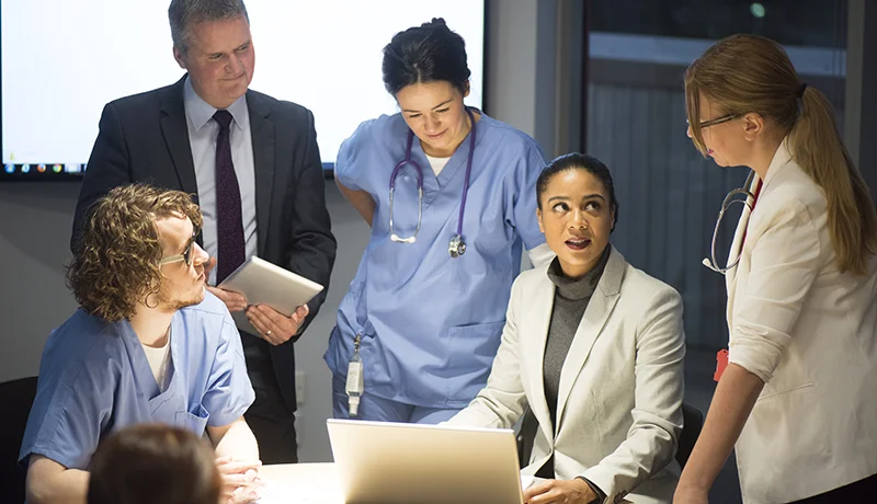 executives and healthcare management degree holders meeting in a conference room