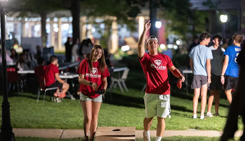 two students playing cornhole