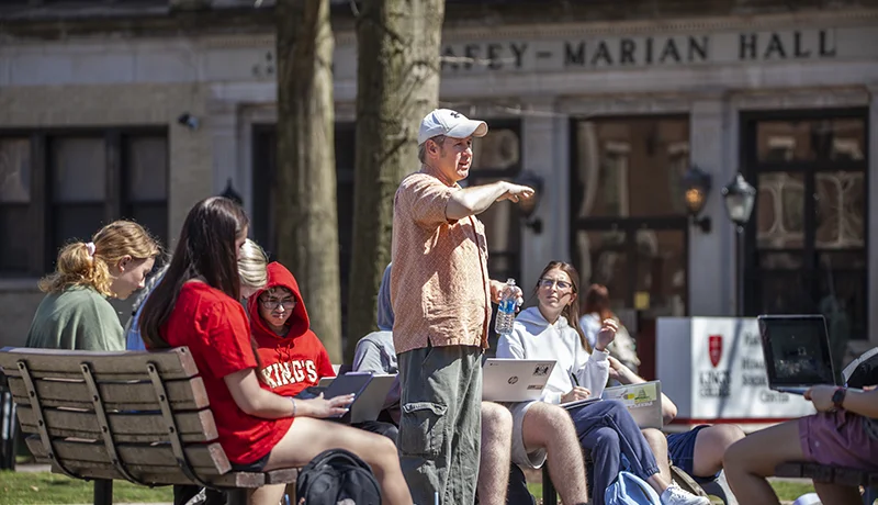 professor teaching a group of philosophy major students outdoors