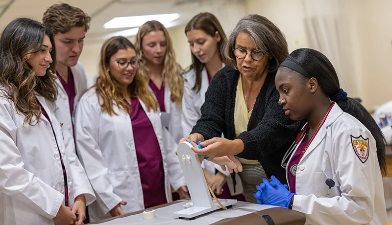 students in labcoats and medical scrubs meeting