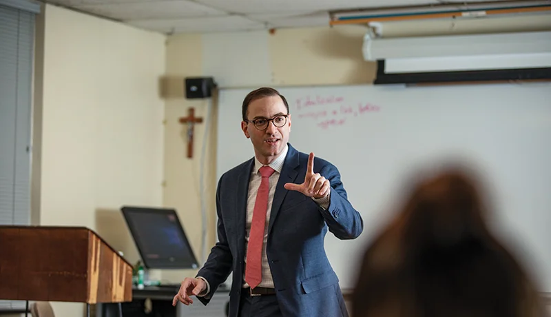 Professor speaking to students in classroom.