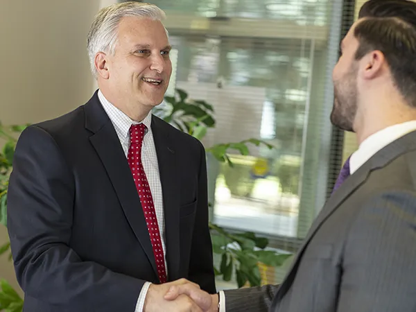 student in suit asking professor what can you do with a business administration degree