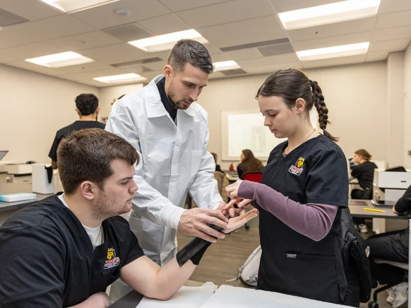 two students in lab coats at King's occupational therapy school
