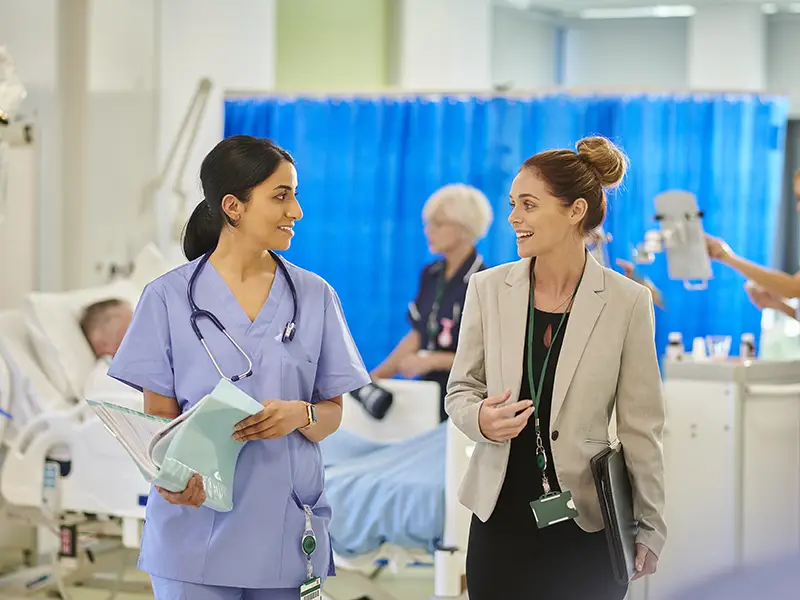 a nurse meets with a manager in a clinical environment