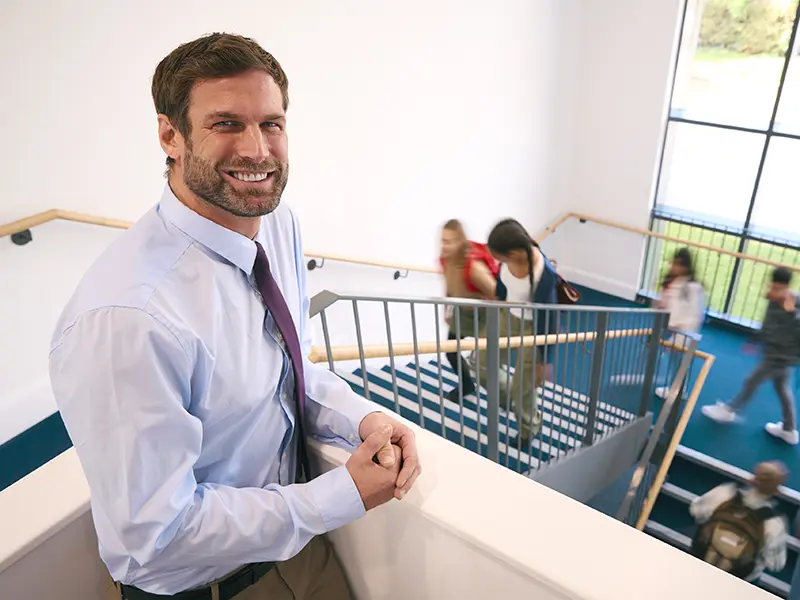 a school superintendent standing in a school stairwell