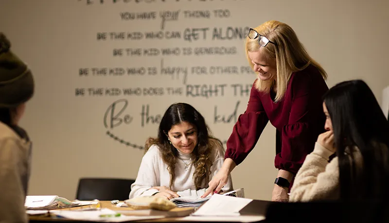 a teacher helping a student at a desk