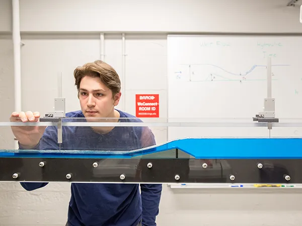 student checking fluid level in a tank