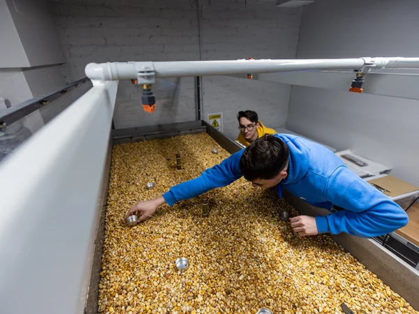 students inspecting material in a container