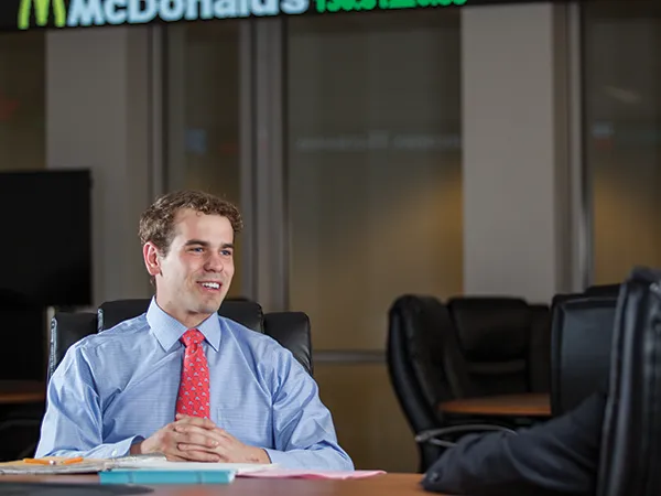marketing degree student in a dress shirt sitting in a conference room