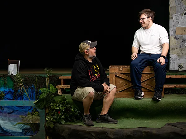 two people talking to eachother on a stage, participating in the theatre program