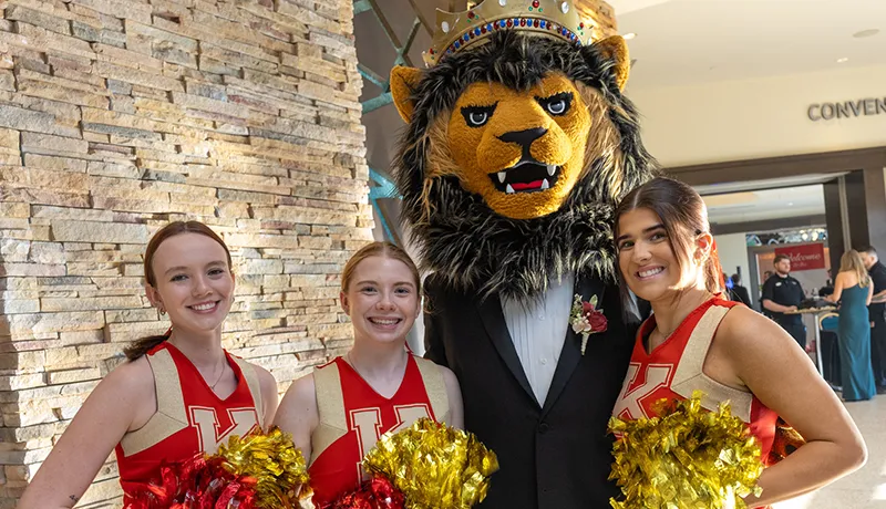 Leo the Lion mascot with several cheerleaders posing