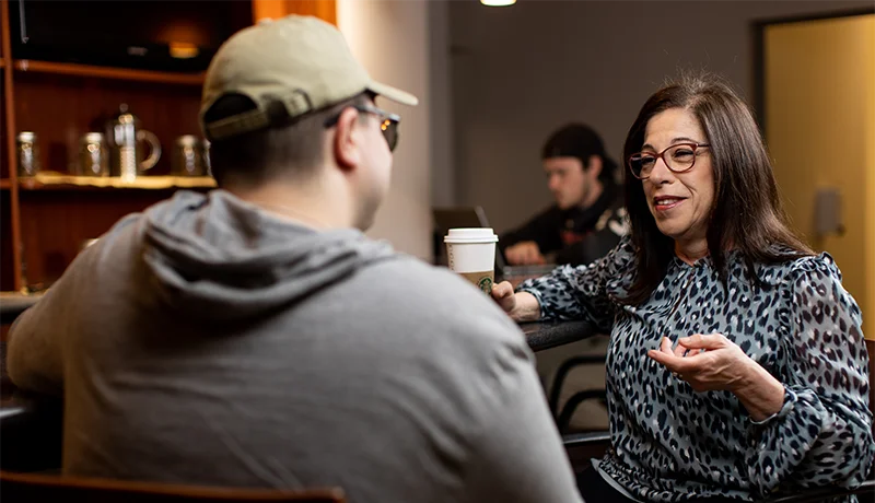 financial aid counselor meets with a student at a coffee shop