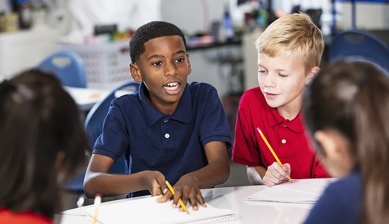 children writing on papers in elementary school