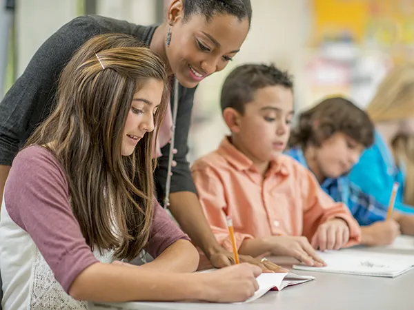a teacher helping children with classwork in school
