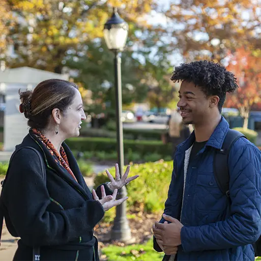 professor talking to a student outdoors