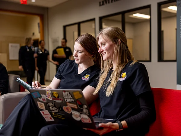 several occupational therapy students reading a textbook in a clinical setting