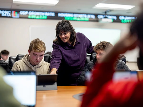 professor instructing an accounting degree student using a laptop