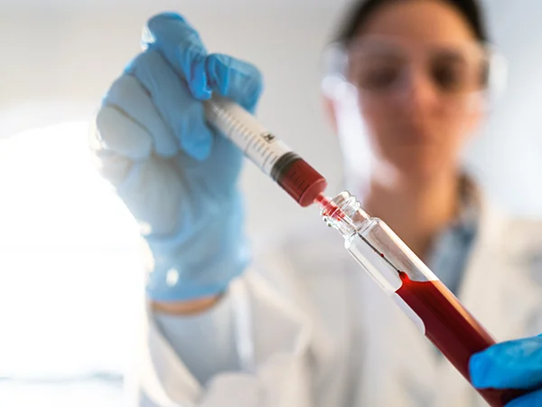 student emptying a syringe into a vial