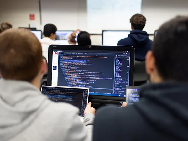students entering computer code on a laptop