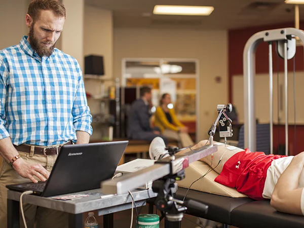 professor demonstrating the use of exercise science equipment