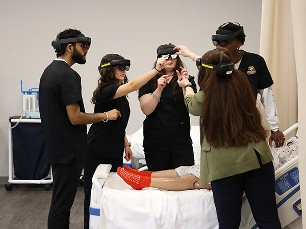 four occupational therapy students wearing protective glasses