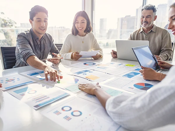 people at a conference table looking at marketing materials