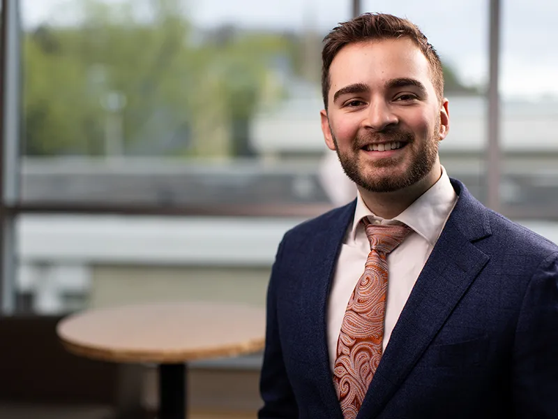 student in a suit smiling