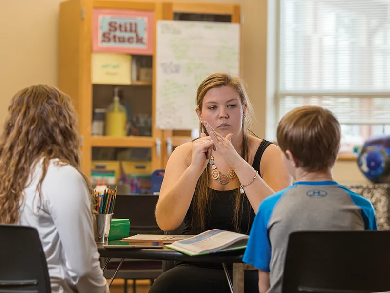 a college student teaching elementary school students