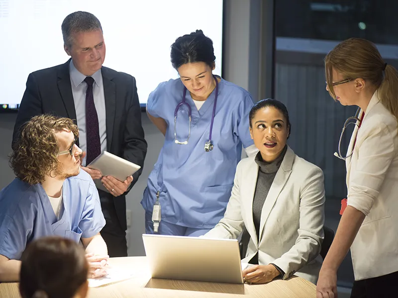 executives meeting with medical professionals in an office environment