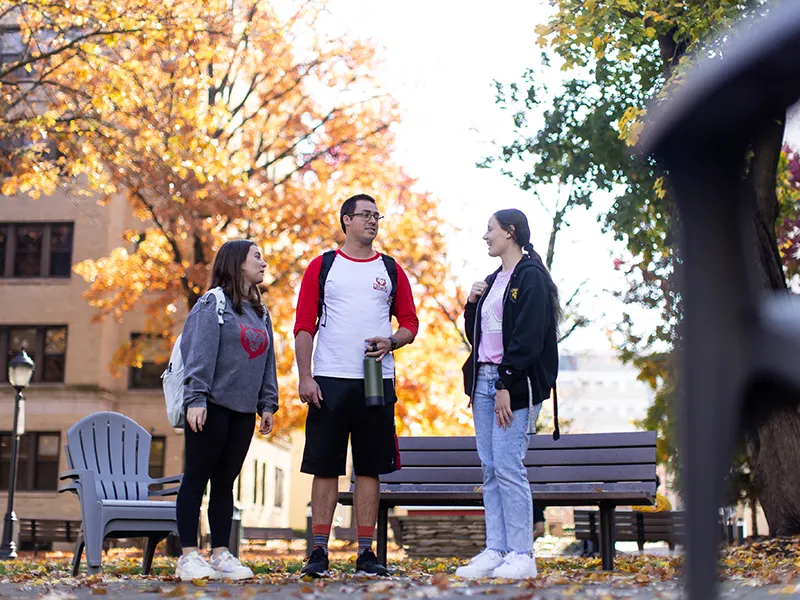 students standing outdoors talking to eachother