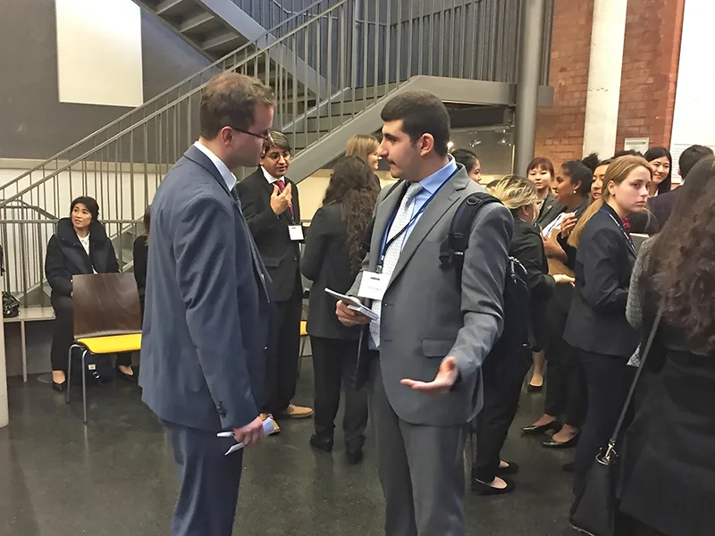 students in suits shaking hands