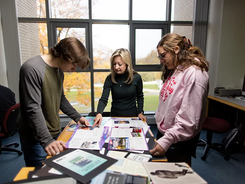 students and a professor looking at marketing flyers