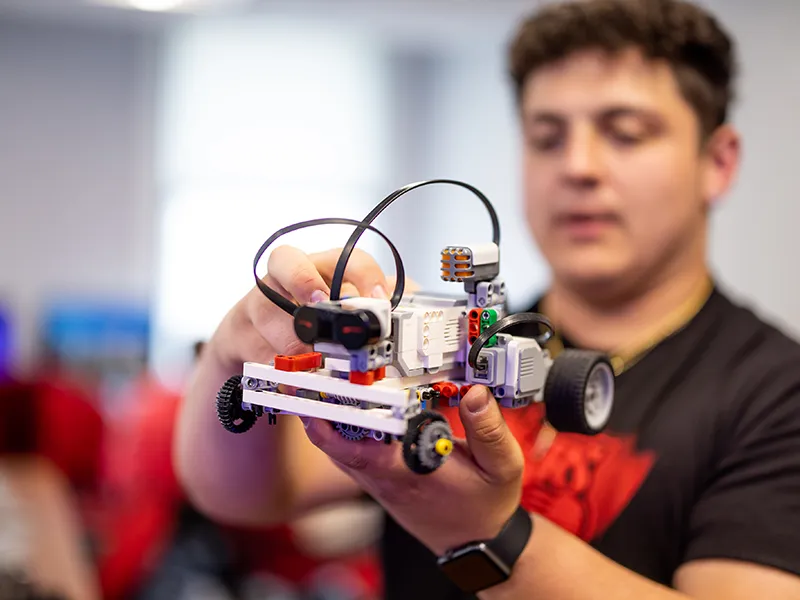 Student displaying a Lego car machine