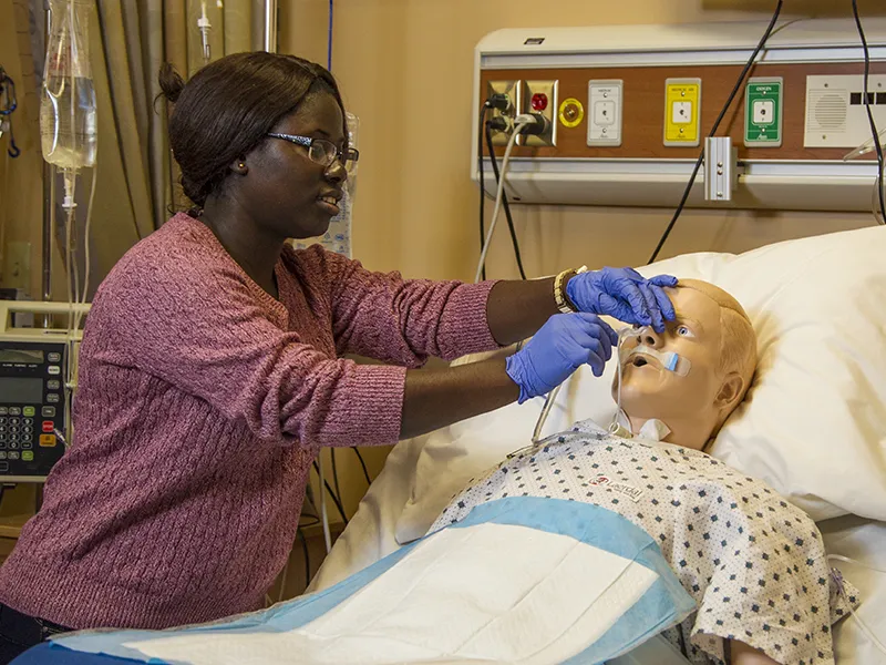 a nursing student checking vitals on a dummy near the physician assistant school