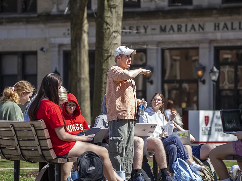 Professor teaching students outside