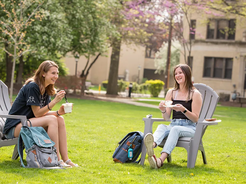 students sitting in Adirondack chairs outdoors