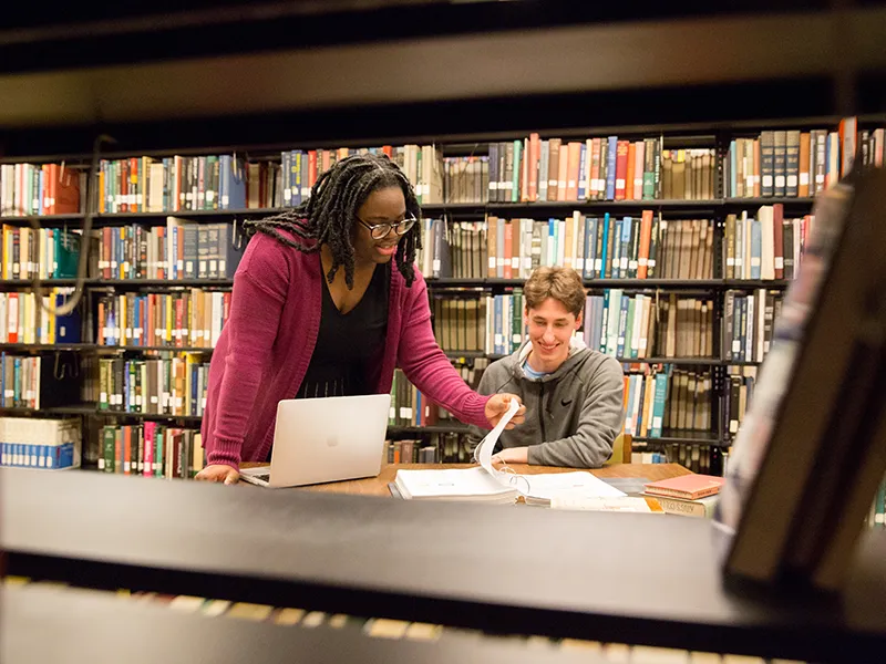 student and professor studying in a library