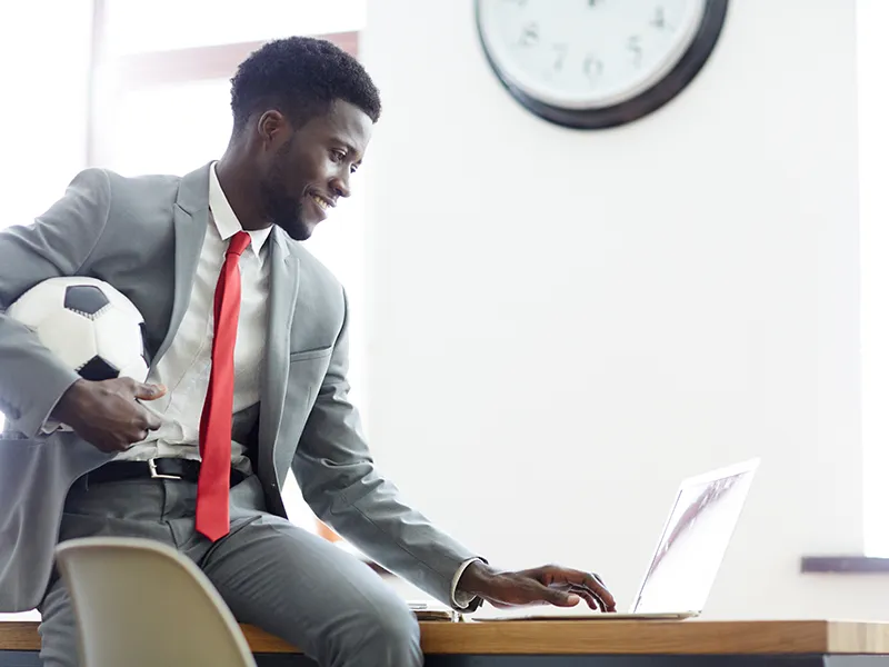 a student in a suit holding a soccer ball