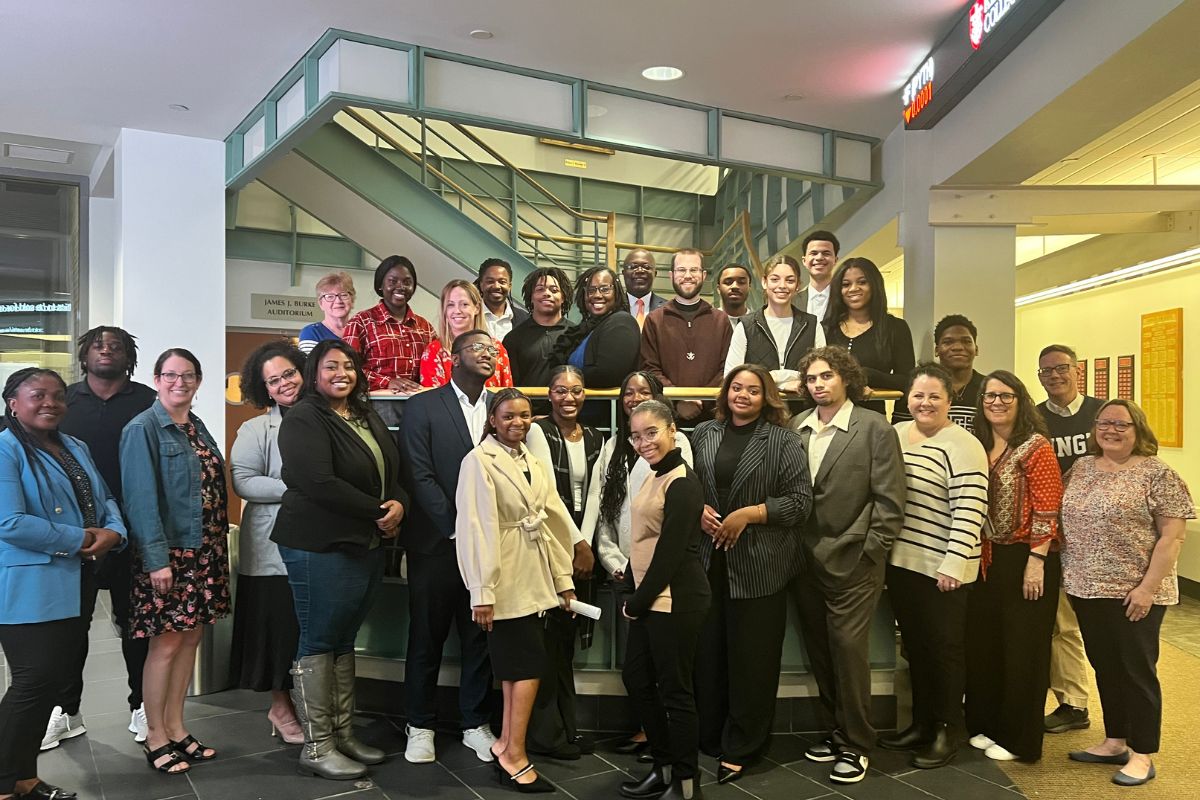 Group photo of students, faculty, and community members at the event.