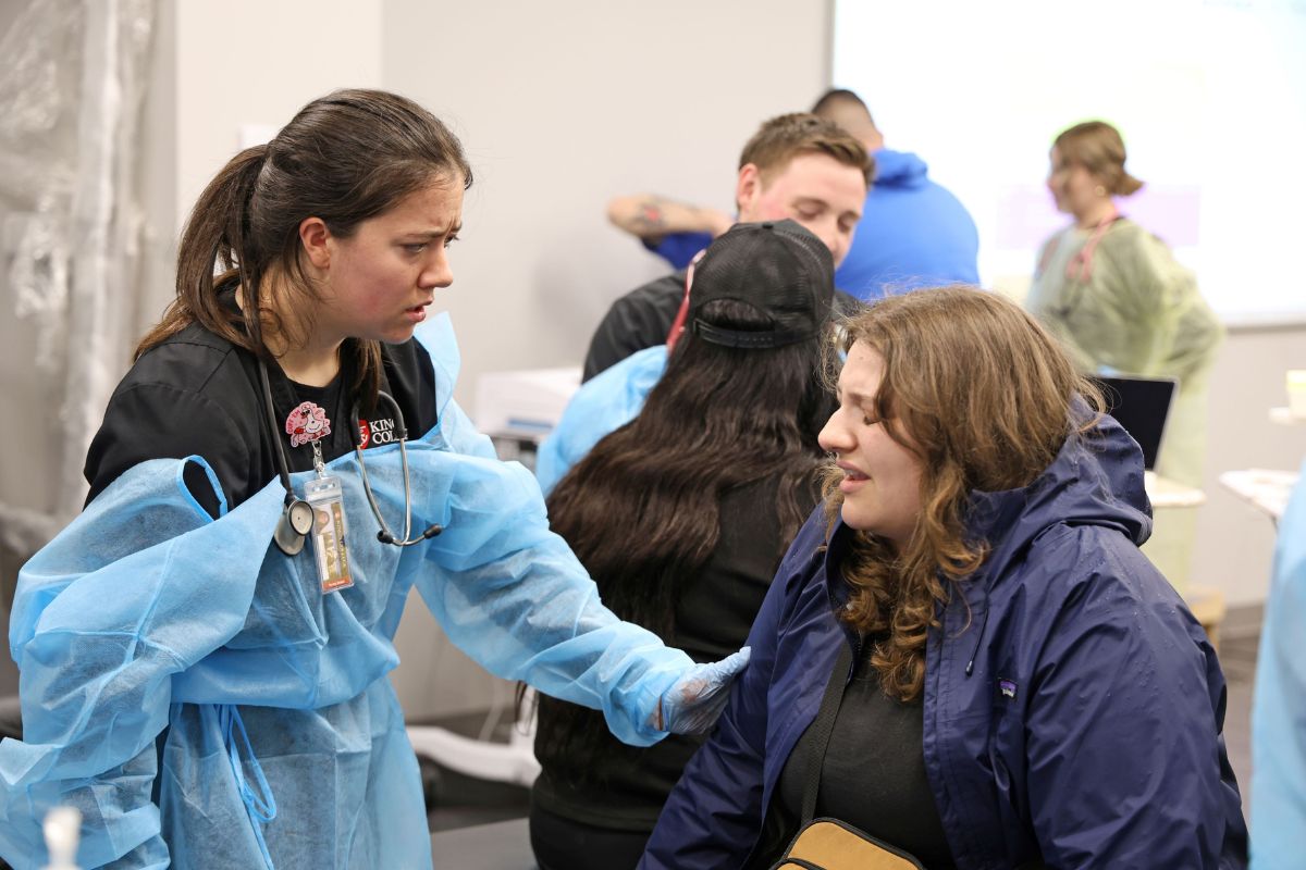 Jackie Costello, ABSN nursing student, looks concerned as the actor arrives in her section of the simulation