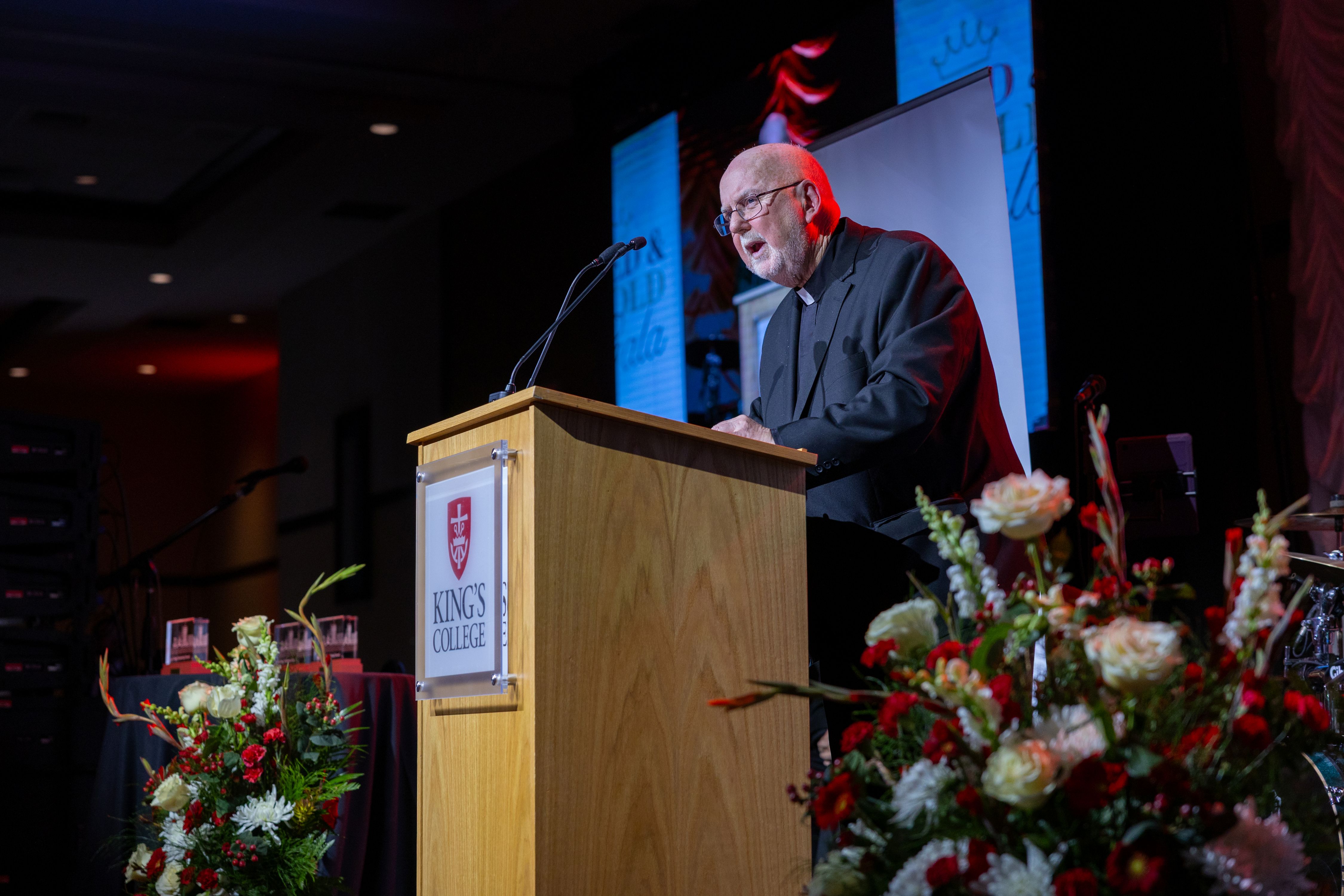 Rev. Thomas O’Hara, C.S.C., Ph.D. ’71, speaking at podium to accept the Lifetime Achievement Award.