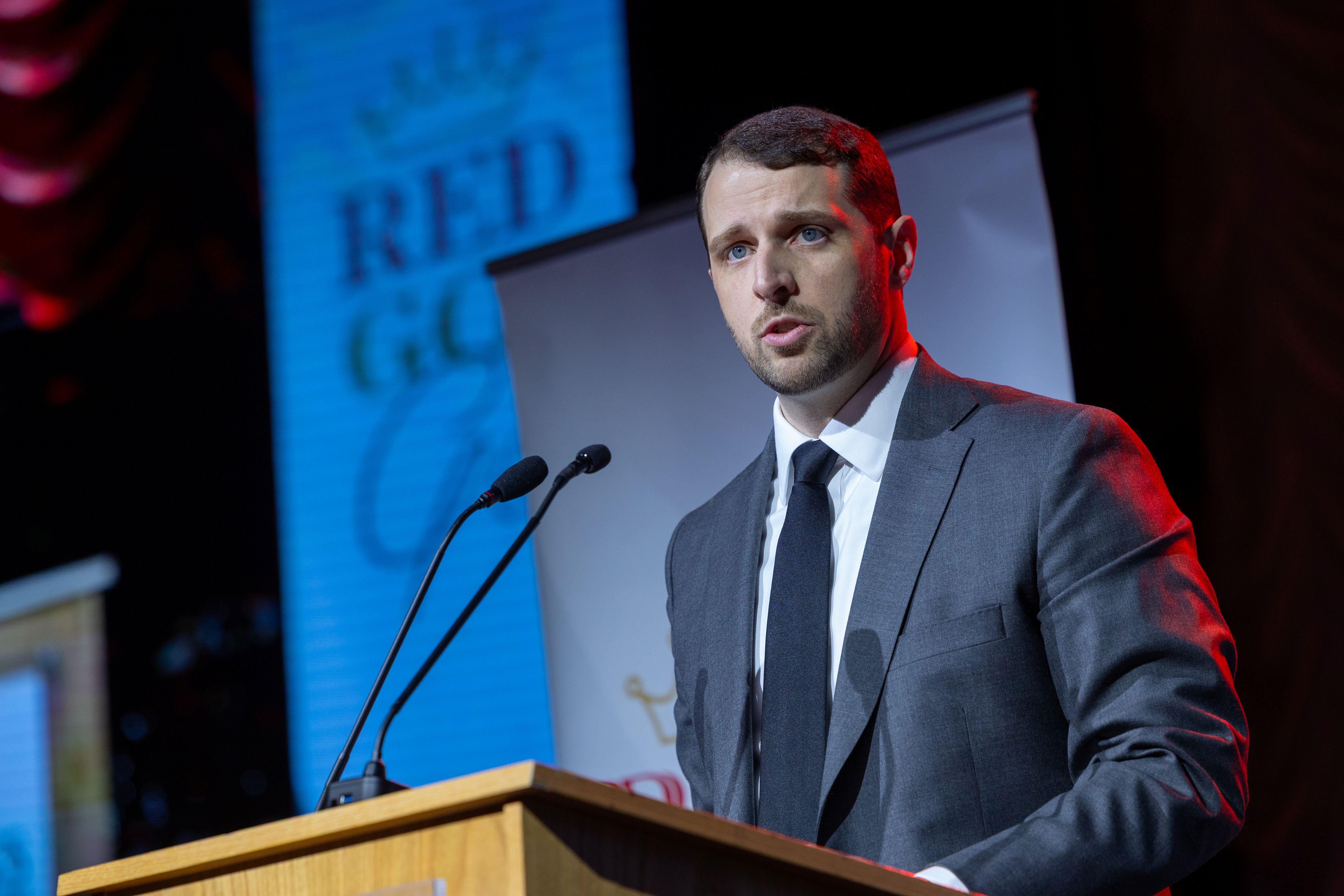 William Joyce Jr.’12 speaking at the podium to accept the Organizational Excellence Award for Risk Strategies, Joyce Insurance Group. 