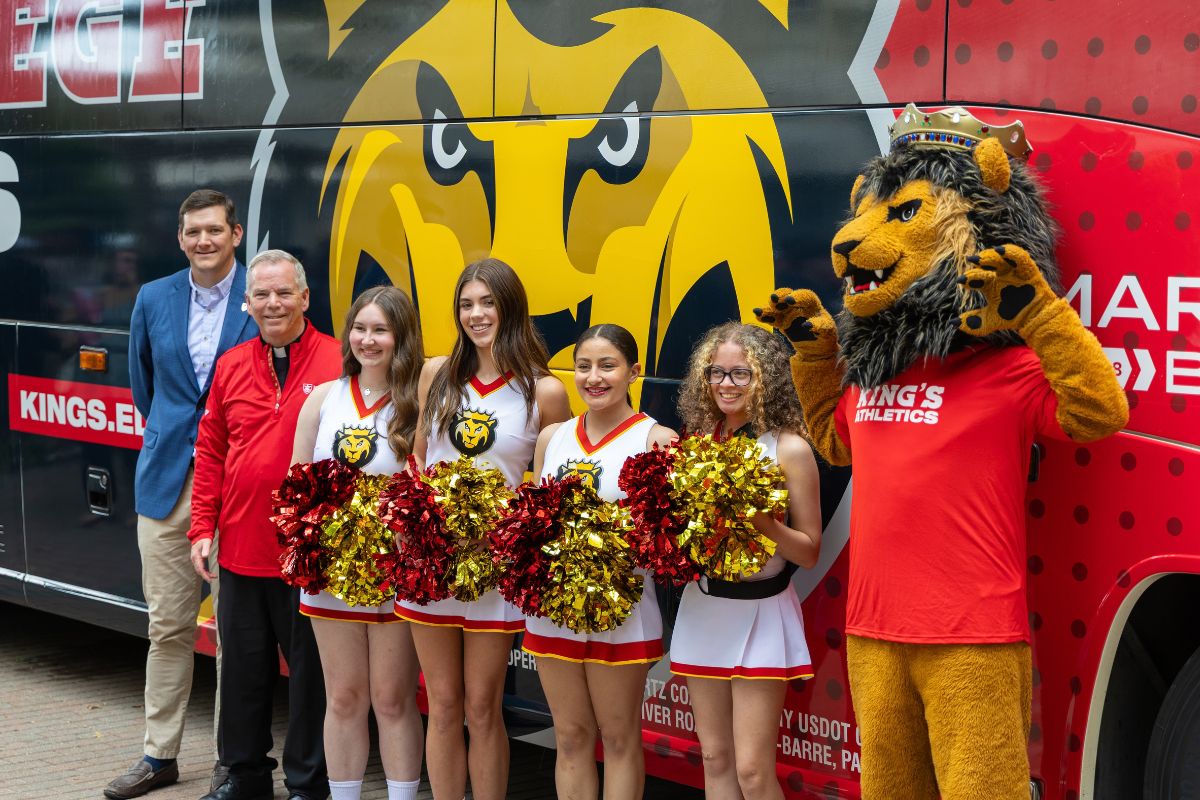 Image of Scott Henry, Fr. Looney, and Cheerleaders